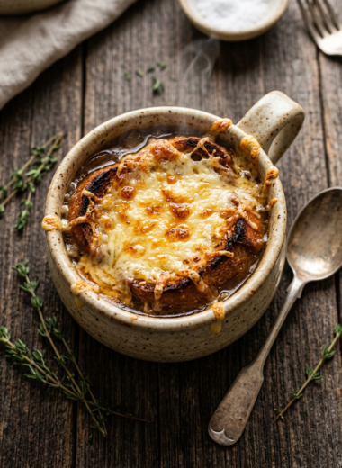 Restaurant-style French onion soup with bubbling Gruyère cheese topping in rustic ceramic bowl