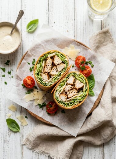 Chicken caesar wrap cut in half showing fresh romaine lettuce, grilled chicken, and creamy dressing