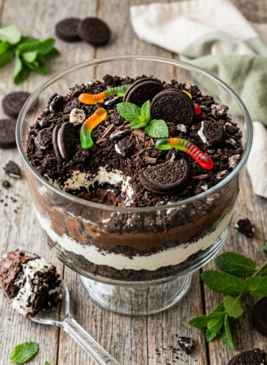 Classic dirt cake recipe with crushed Oreo layers, chocolate pudding, and whipped cream in clear glass bowl