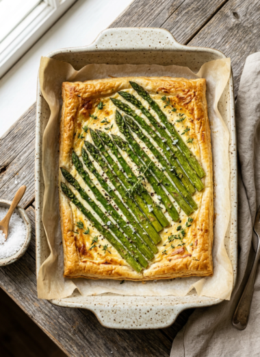 Golden baked spring asparagus tart with charred green spears on crispy puff pastry