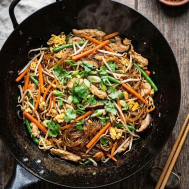 Authentic Thai glass noodles stir-fried with vegetables in wok, translucent mung bean noodles glistening with sauce
